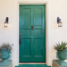 Green entry door with door knock.