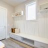 Pretty entrance foyer with a wall clad in board and batten lined with an extra long built-in bench with storage drawers topped with white and brown pillows. Northwest, USA