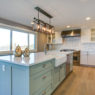 Beautiful kitchen room with green island and farmhouse sink.